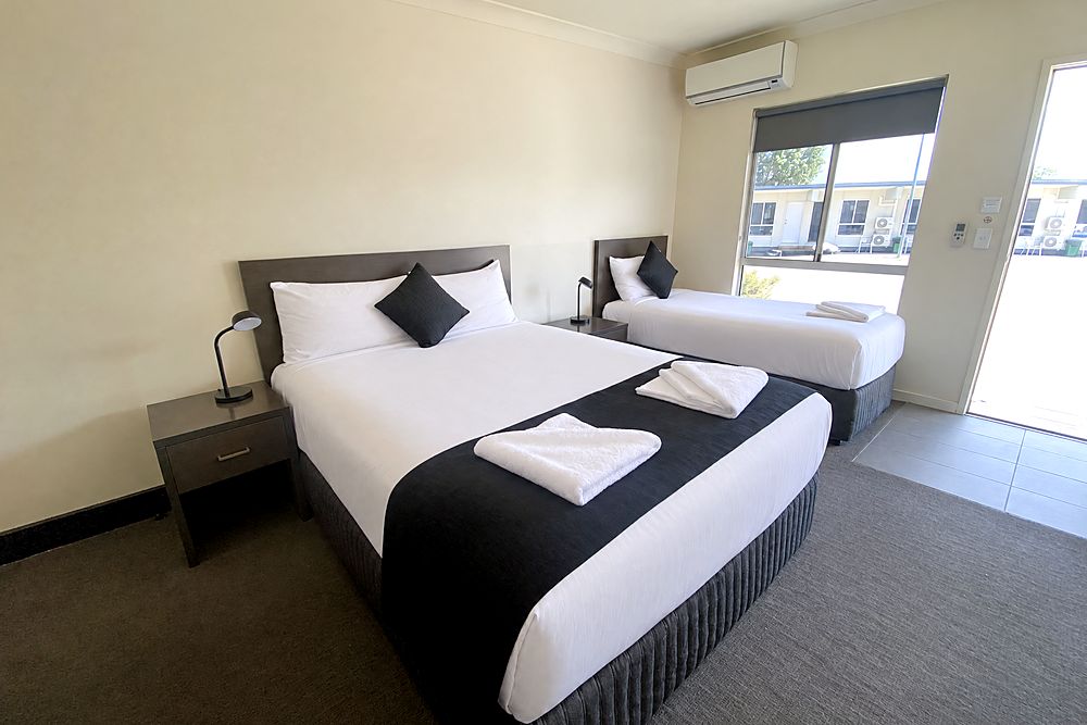 Deluxe Twin room with a queen bed and a king single by the window